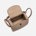 A taupe pebbled vegan leather Lindy bag with side-set handles, a shoulder strap, and silver circular turn-locks. Additional product view 5.
