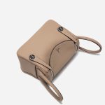 A taupe pebbled vegan leather Lindy bag with side-set handles, a shoulder strap, and silver circular turn-locks. Additional product view 8.