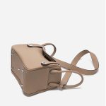 A taupe pebbled vegan leather Lindy bag with side-set handles, a shoulder strap, and silver circular turn-locks. Additional product view 9.