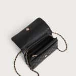A small black diamond-quilted vegan leather flap bag with a gold flower emblem and a leather-woven gold chain strap. Additional product view 4.