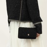 A small black diamond-quilted vegan leather flap bag with a gold flower emblem and a leather-woven gold chain strap. Additional product view 5.