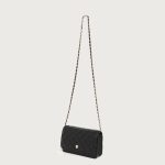 A small black diamond-quilted vegan leather flap bag with a gold flower emblem and a leather-woven gold chain strap. Additional product view 7.