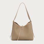 A taupe pebble-grain vegan leather hobo worn on the shoulder, showing gold hardware and a striped interior lining. Additional product view 5.