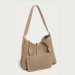 A taupe pebble-grain vegan leather hobo worn on the shoulder, showing gold hardware and a striped interior lining. Additional product view 6.