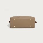 A taupe pebble-grain vegan leather hobo worn on the shoulder, showing gold hardware and a striped interior lining. Additional product view 9.