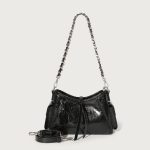 A glossy black crinkled vegan leather underarm bag with snap cargo side pockets, a chain strap, and a small luggage tag. Additional product view 3.