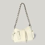A glossy black crinkled vegan leather underarm bag with snap cargo side pockets, a chain strap, and a small luggage tag. Additional product view 2.
