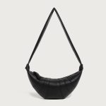 A coffee brown vegan leather croissant bag with vertical ribbed panels, knotted strap joins, and a curved top zipper. Additional product view 2.