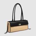 A rectangular straw raffia baguette with a black vegan leather flap, gold turn-lock, dual straps, and side leather tassels. Additional product view 6.