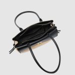 A rectangular straw raffia baguette with a black vegan leather flap, gold turn-lock, dual straps, and side leather tassels. Additional product view 7.
