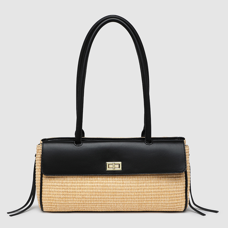 A rectangular straw raffia baguette with a black vegan leather flap, gold turn-lock, dual straps, and side leather tassels.