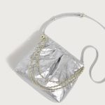 A pastel pink quilted vegan leather pouch with a gathered top, gold chain strap, and a detachable flat crossbody strap. Additional product view 7.