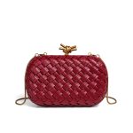 A metallic gold woven vegan leather box clutch with a knotted metal clasp and a thin gold snake-chain strap. Additional product view 5.