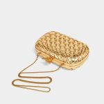 A metallic gold woven vegan leather box clutch with a knotted metal clasp and a thin gold snake-chain strap. Additional product view 2.