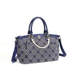A navy and gray monogram jacquard tote with vegan leather trim, gold hardware, dual handles, and a faux pearl chain.