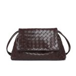 A black woven vegan leather shoulder bag with a large fold-over flap and thin tubular straps on a white background. Additional product view 2.