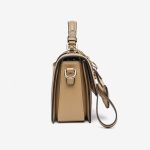A beige and tan monogram satchel with a top handle, gold buckle, teddy-bear charm, and two detachable shoulder straps. Additional product view 5.
