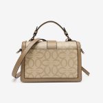A beige and tan monogram satchel with a top handle, gold buckle, teddy-bear charm, and two detachable shoulder straps. Additional product view 6.