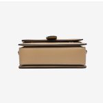 A beige and tan monogram satchel with a top handle, gold buckle, teddy-bear charm, and two detachable shoulder straps. Additional product view 7.
