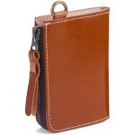 A cognac vegetable-tanned leather zip wallet with white contrast stitching, a brass D-ring, and a leather zipper pull on a white background.