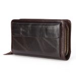 A black top-grain leather long wallet with a front flap, zip-around closure, and leather zipper pull on a white background. Additional product view 5.