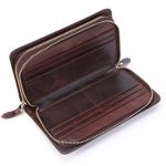 A black top-grain leather long wallet with a front flap, zip-around closure, and leather zipper pull on a white background. Additional product view 6.