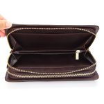 A black top-grain leather long wallet with a front flap, zip-around closure, and leather zipper pull on a white background. Additional product view 7.