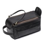 A vintage brown leather toiletry bag with dual zippers, a front flap pocket, side handle, and brass feet on a white background. Additional product view 7.